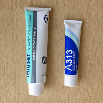 Two tubes of Ialuset and A313 cream on a wooden surface
